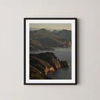 Freycinet art print showing an aerial view of the Tasmanian coastline and ocean at sunrise, displayed on a wall in a black frame.