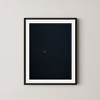 Voyage art print featuring a single sailing boat on the ocean, displayed on a wall in a black frame.