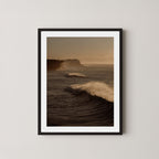 Wave Appreciation art print of Bronte, Sydney with waves and cliffs displayed on a plain wall in a black wooden frame.