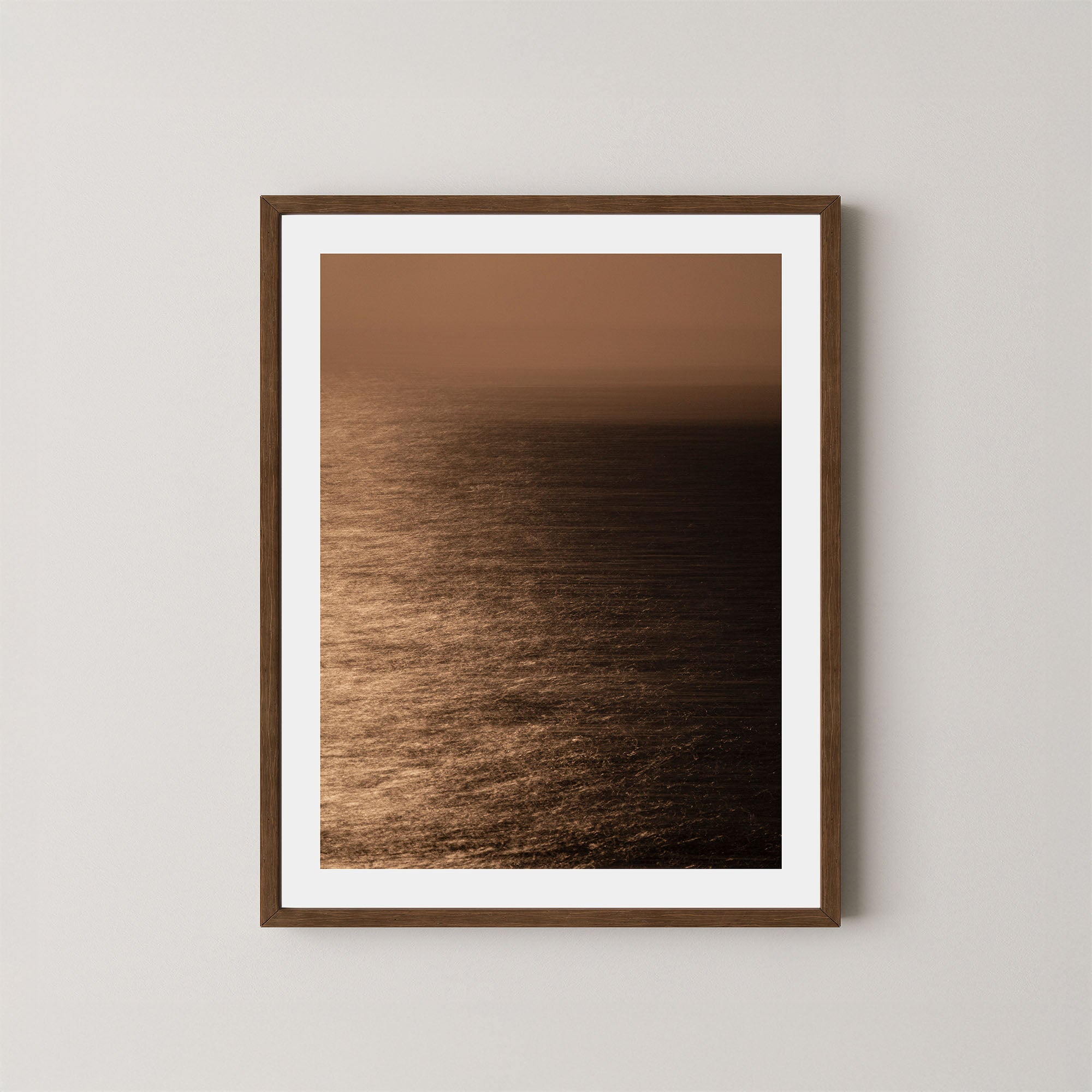 Art print of the Sydney ocean illuminated by moonlight, with rich golden and dark tones, shown on a wall in a dark wooden frame.