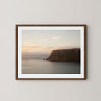 Silent Coast art print of a coastal cliff and sunrise in Stanley, Tasmania, displayed on a white wall in dark wooden frame.