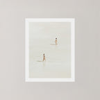 Beach Crossing photography art print featuring two women walking in opposite directions on a light, sandy beach at low tide in Byron Bay, Australia.