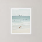 Wategos Calm photo art print of a surfer walking with a surfboard on the beach in Byron Bay, Australia, with the ocean and other surfers in the background.