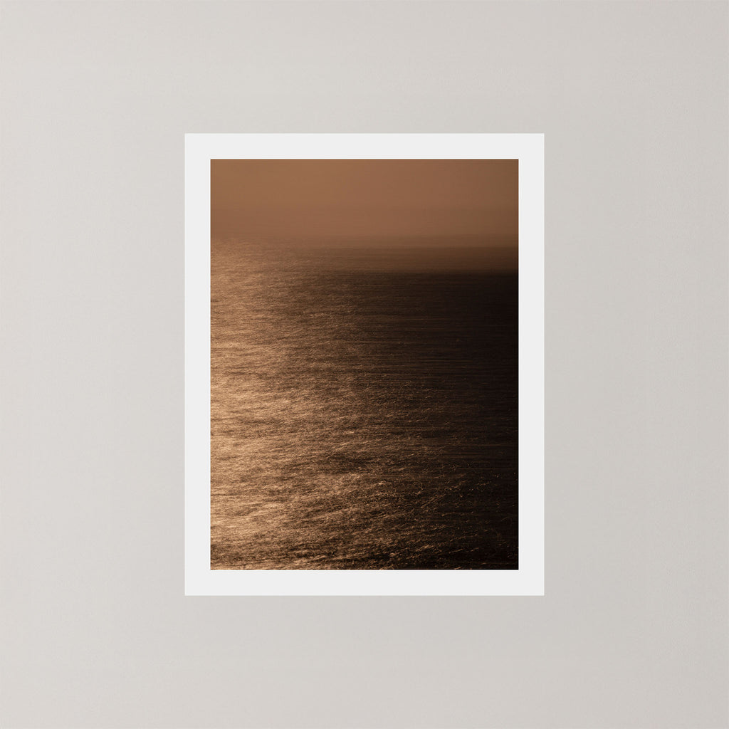 Photography art print of the Sydney ocean illuminated by moonlight, with rich golden and dark tones.