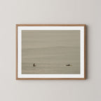 Ocean Therapy art print of two surfers on a calm ocean at Byron Bay, Australia, displayed on a wall in natural wooden frame.