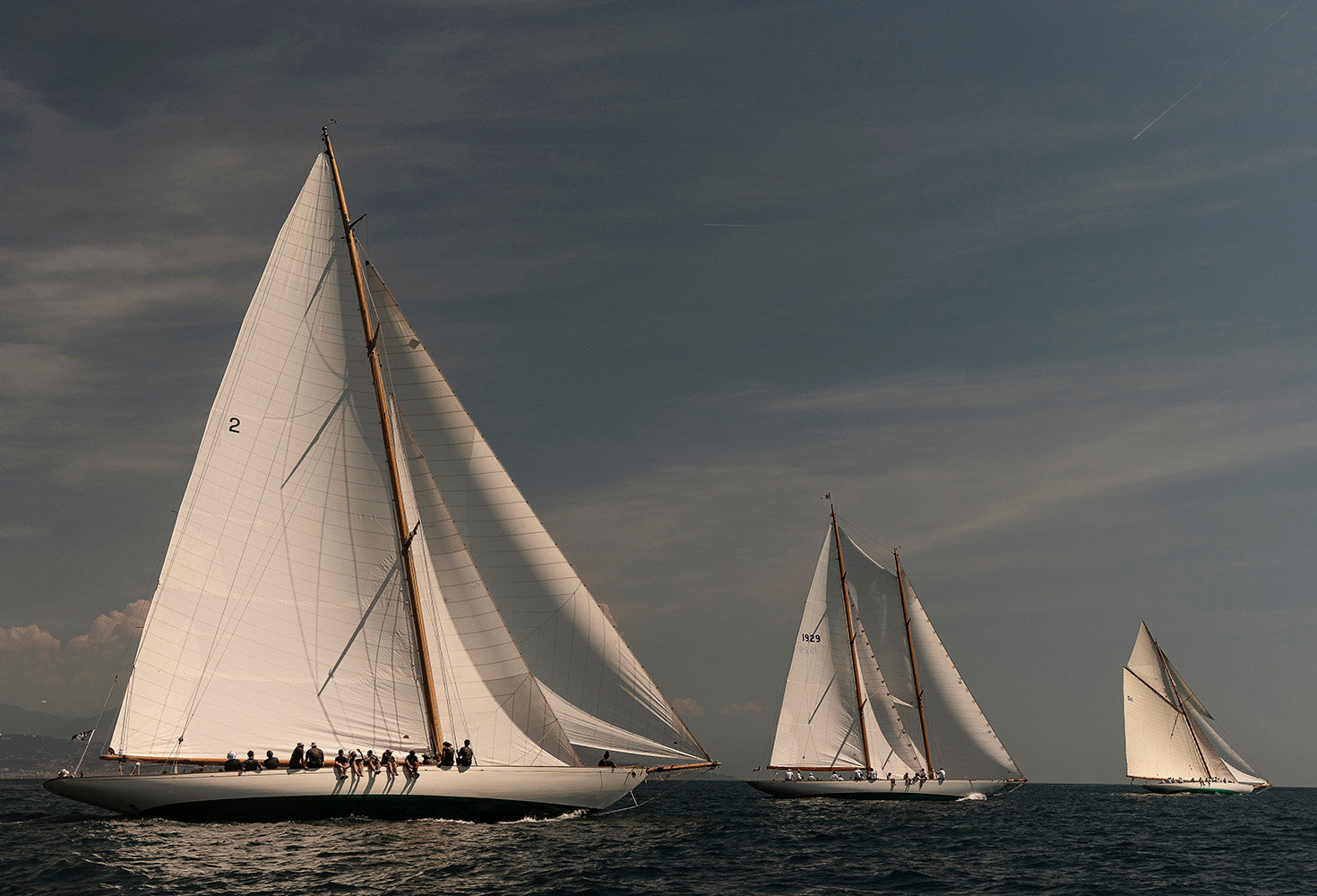Three white-sailed sailboats racing on the sea outside Antibes, France.