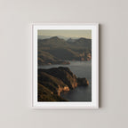 Freycinet art print showing an aerial view of the Tasmanian coastline and ocean at sunrise, displayed on a wall in a white frame.