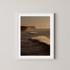 Wave Appreciation art print of Bronte, Sydney with waves and cliffs displayed on a plain wall in a white frame.